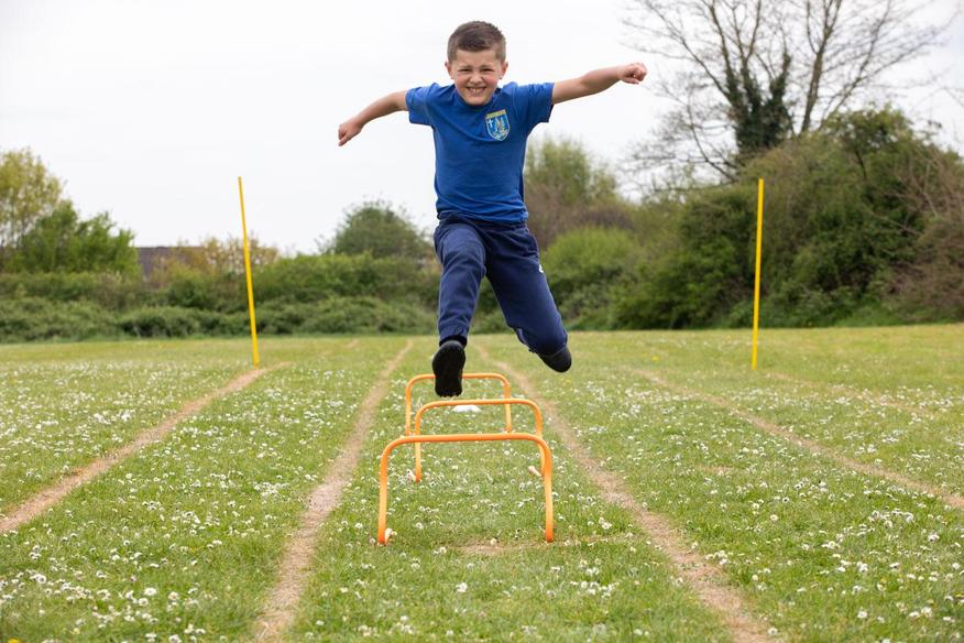 Boy jumping over hurdles